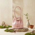 Close-up of pink bucket bag with floral jacquard texture and bow detail - Pink