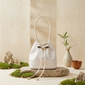 Detail of cream drawstring bucket bag with floral jacquard texture on natural stone base - Off White