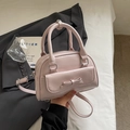 Light pink minimalist bowling bag with a bow pocket and adjustable crossbody strap - No Pendant / Pink