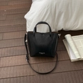 Chic black leather bucket bag with top handles and silver lettering on wooden floor - Black without Pendant