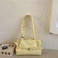 Detail of light yellow tote bag featuring glossy wrinkled texture and metallic eyelet buckles - Yellow
