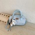 Detail einer hellblauen Boston Bag mit Karomuster und pferdeförmigem Lederanhänger - Blau mit Anhänger