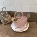 Dettaglio della borsa a secchiello in pelle rosa con incisione NO FILTER e ciondolo - Rosa