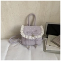 Detalle de mochila lavanda con lunares blancos, encaje y colgante de corazón dorado - Morado
