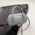 Light blue bowling bag with lychee texture and silver hardware on a grey blazer background - No Pendant / Blue