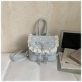 Gros plan d'un mini sac à dos bleu clair avec pois blancs et bordures en dentelle - Bleu