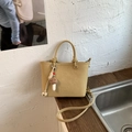 Detail of yellow faux leather tote with MUT ING logo and plush mushroom pendant - With Charm / Khaki