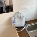 Detail of light blue crossbody bag featuring embossed logo and cute mushroom pendant - With Charm / Blue