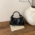 Dettaglio della borsa a nuvola nera a pieghe su libri con uno stile interno minimalista - Nero