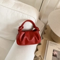 Sac nuage rouge plissé avec poignée nouée posé sur un canapé blanc moderne - Rouge