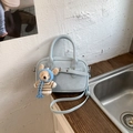 Détail du sac oreiller bleu clair vintage avec charm ours sur surface en bois - Bleu avec Pendentif