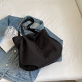 Minimalist black nylon tote bag with leather logo patch and durable woven shoulder strap - Black