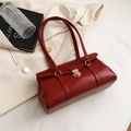 Sac à main vintage rouge foncé en cuir synthétique avec fermoir doré sur fond de blazer - Rouge