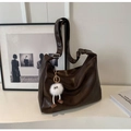 Detail der tiefbraunen Hobo-Tasche mit Vintage-Textur und flauschigem Monster-Anhänger - Mit Anhänger / Kaffeebraun