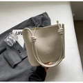 Chic beige bucket bag with litchi texture and unique knotted handles with gold metal ends - Off-white