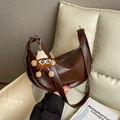 Dunkelbraune Hobo-Tasche aus glattem Kunstleder mit süßem Monster-Plüsch-Anhänger - Kaffeebraun