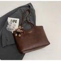 Detail view of brown leather tote bag featuring gold lettering and cute bear charm pendant - With Pendant / Brown