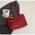 Macro shot of red leather tote bag texture with fashion lettering and bunny charm - With Pendant / Burgundy