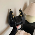 Glossy black underarm bag with gold metal buckles and textured leather finish - Black