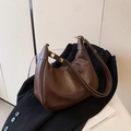 Chic brown synthetic leather hobo bag with gold metal rings on a black suit jacket - Coffee