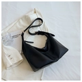 Minimalist black matte leather hobo bag with adjustable strap on white blazer - Black