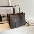 Minimalist grey canvas tote bag with brown leather trim and shoulder strap in art studio - Dark Brown