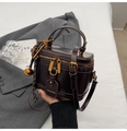 Dunkelbraune Retro-Tasche aus glänzendem Leder mit goldenem Reißverschluss und Anhänger - Braun