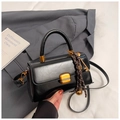 Retro black leather crossbody bag with gold hardware and woven key charm on a blazer - Black With Pendant