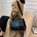 Elegante bolso negro con textura de cocodrilo, correa ancha y herrajes en tono dorado - Negro