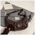 Detaillierte Nahaufnahme der dunkelbraunen Hobo-Tasche aus weichem Leder mit Vintage-Falten - Braun