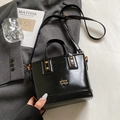 Secchiello chic in pelle cerata nera con logo in metallo dorato e tracolla regolabile - Stile di base / Nero