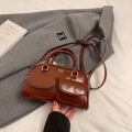 Brown vintage faux leather bowling bag with twin front pockets and silver hardware on a coat - Brown (Without Pendant)