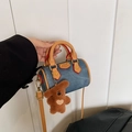Détail d'un mini sac cylindrique en denim avec garniture en cuir brun et un ourson en peluche - Pendentif Ours Cœur / Bleu Denim