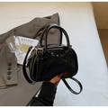 Close-up of black leather bowling bag with bow detail and adjustable shoulder strap - Black