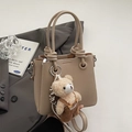 Beige litchi grain bucket bag with unique knotted handle and cute plush bear charm - With Plush Bear Pendant / Apricot