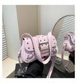 Détail du sac bandoulière punk rose avec clous argentés et boucle métallique en scène - Rose