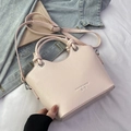 Schicke hellrosa Beuteltasche mit Litschi-Struktur und Knotendetail vor Lifestyle-Kulisse - Rosa - Ohne Anhänger