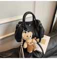Détail d'un sac seau noir en cuir grainé avec un charmant pendentif d'ours en peluche - Avec Pendentif / Noir