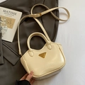 Schicke cremeweiße Eimer-Tasche aus Ölwachsleder mit goldenem Logo und Umhängegurt - Off-White - Ohne Anhänger