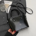 Borsa a secchiello minimalista in pelle cerata nera lucida con manico e tracolla - Nero