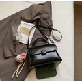Detailansicht der schwarzen Mini-Tasche aus Kunstleder mit Affen-Anhänger und Gurt - Schwarz Mit Anhänger