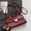 Borsa a mano in pelle lucida bordeaux con manico e tracolla su un blazer grigio - Senza Ciondolo / Borgogna