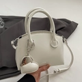 Minimalist white leather handbag with round handles and a gold heart pendant charm - Rice White With Heart Charm