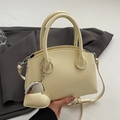 Minimalist cream beige top-handle crossbody bag with heart charm and brand logo - Light Yellow With Heart Pendant