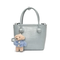 Minimalist light blue bucket bag with a cute teddy bear charm and sleek leather handles - Blue With Blue Sweater Dog