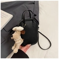 Close-up of black lychee grain mini handbag with cute cartoon dog plush charm - Black With Pendant
