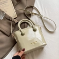 Minimalistische hellgrüne Bucket Bag aus Kunstleder mit Goldschrift auf weißem Bett - Grün - Ohne Anhänger