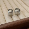 Detalle de pendientes de aro cuadrados plateados con superficie de metal martillado liso - Plateado