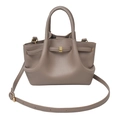 Detailed macro view of taupe leather tote with golden hardware and lychee grain texture - Khaki