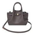 Detailed macro view of textured pebble leather surface and golden metal buckle on dark grey bag - Elephant Gray
